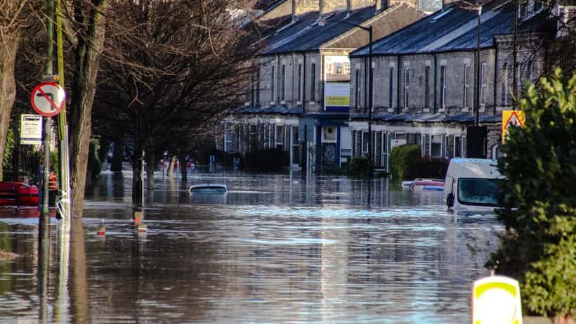 A flooded residential street in York England with houses surrounded by floodwater illustrating real UK disaster risk