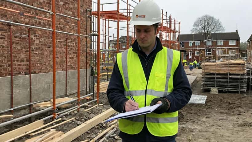 UK builder reviewing cost estimates on a residential construction site