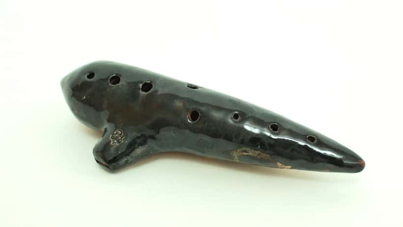 Keramische ocarina muziekinstrument, geblazen door een leerling in een muziekles