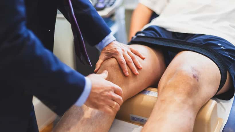 Médecin spécialiste effectuant un bilan isocinétique sur une blessure du ligament croisé antérieur (LCA)