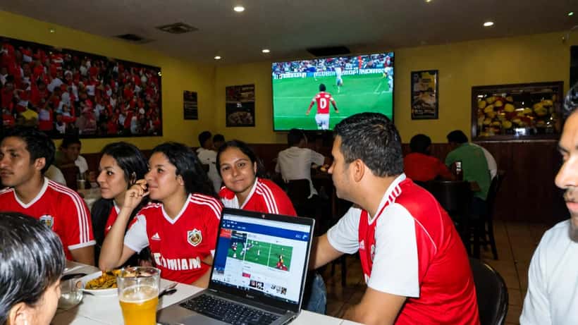 Aficionados colombianos en Estados Unidos viendo un partido de la Liga BetPlay en un restaurante hispano