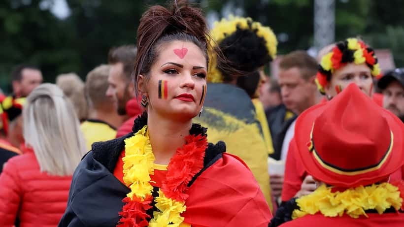 Supporter de football brandissant l'écharpe de son club dans les tribunes d'un stade français, prêt pour le déplacement en Ligue 1