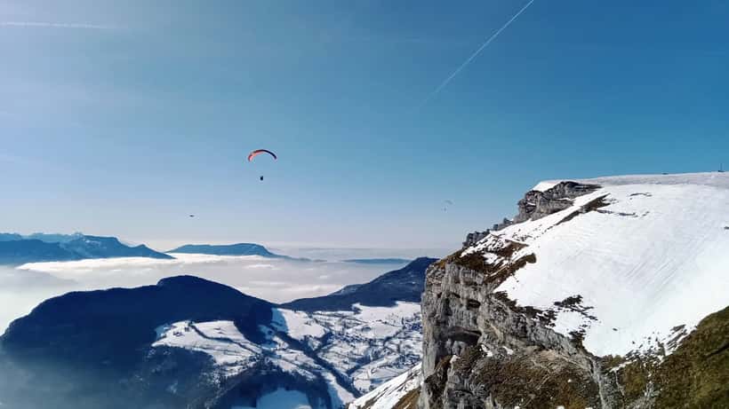 Parapentiste en vol au-dessus d'une falaise en France, ciel nuageux