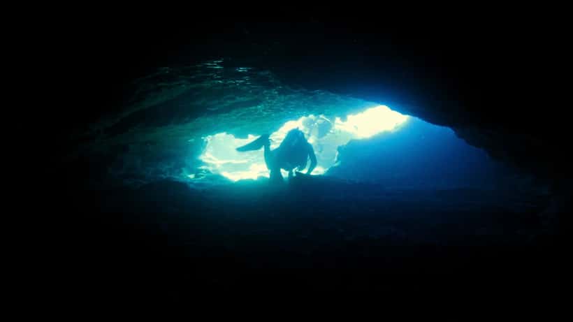 Mergulhadores explorando caverna subaquática em mergulho técnico