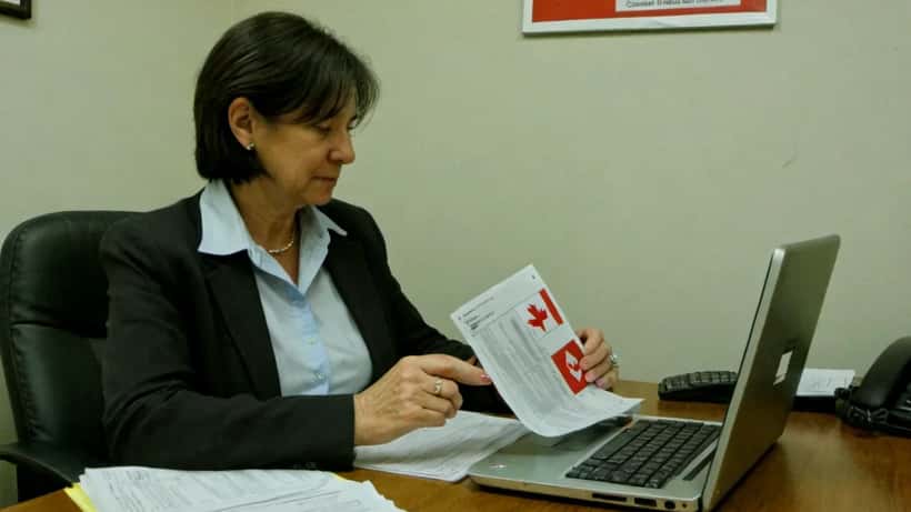 Femme en bureau gouvernemental à Ottawa consultant des documents officiels canadiens