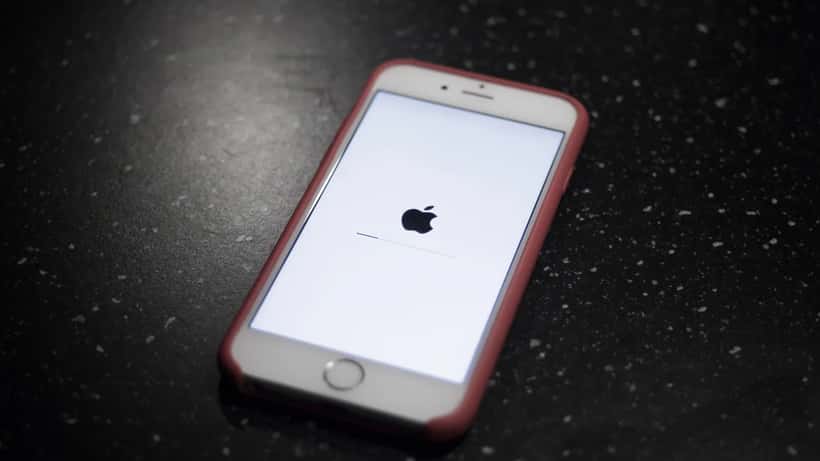iPhone com ecrã de atualização iOS, ilustrando a gestão de atualizações em ambiente empresarial