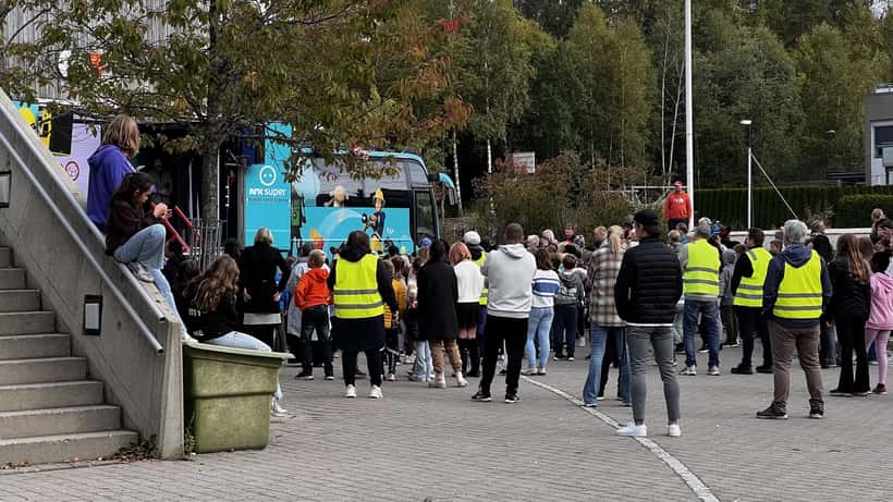 Barn ser begeistret pa NRK Superbussen utenfor en norsk barneskole i Akershus