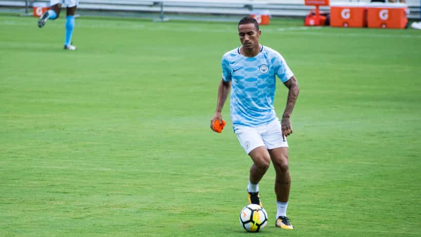 Atleta profissional de futebol assinando novo contrato de transferência, simbolizando direitos trabalhistas no esporte