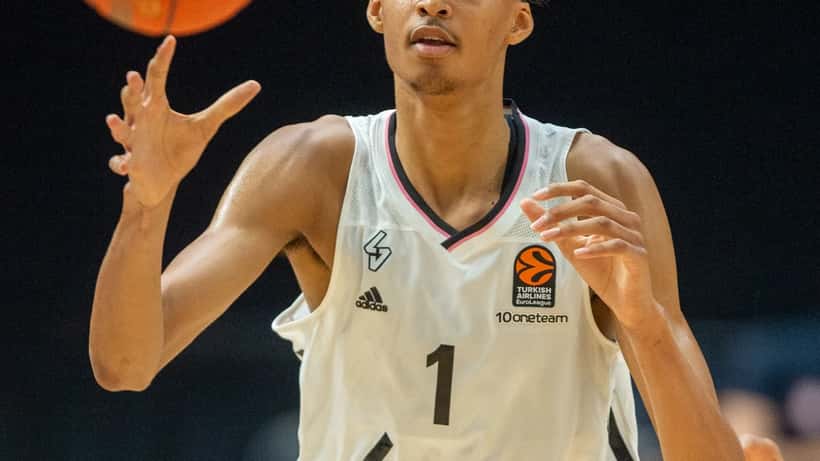 Médecin du sport français expliquant une IRM du genou à un grand basketteur dans une clinique parisienne