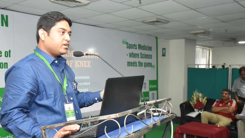 Sports medicine specialist presenting knee examination techniques at a medical conference