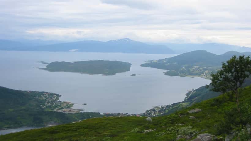 Norsk fjordlandskap med stille vann og grønne fjellsider