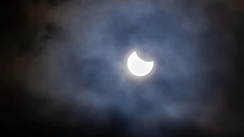 Éclipse solaire partielle avec nuages en Suisse, observation astronomique août 2026