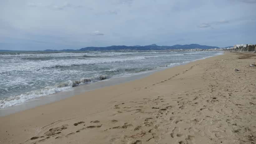 Arenal strand op Mallorca met turquoise water en vakantieboten in de achtergrond