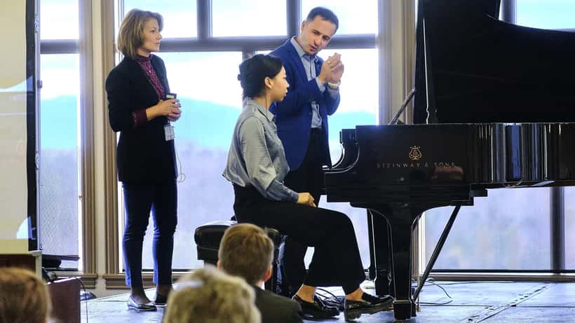 Professeur de piano donnant une masterclasse à des étudiants adultes