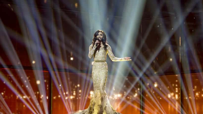 Optræden på Eurovision Song Contest scene med stærk belysning og stor skærm i baggrunden