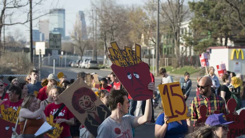 Trabalhadores em greve com cartazes de reivindicação laboral