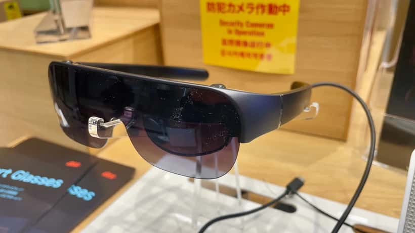 Person wearing smart glasses with a built-in camera outdoors in Australia
