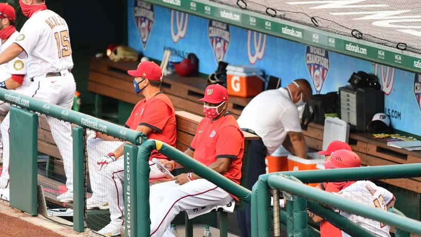 Baseball manager watching intently from the dugout during a high-stakes game
