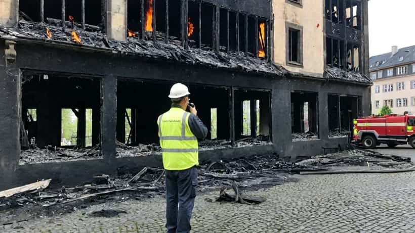 Expert en bâtiment inspectant une façade noircie après un incendie à Strasbourg