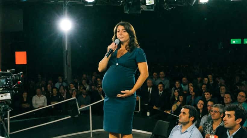 Mulher grávida apresentadora de televisão em estúdio em Lisboa ilustrando direitos das trabalhadoras grávidas em Portugal