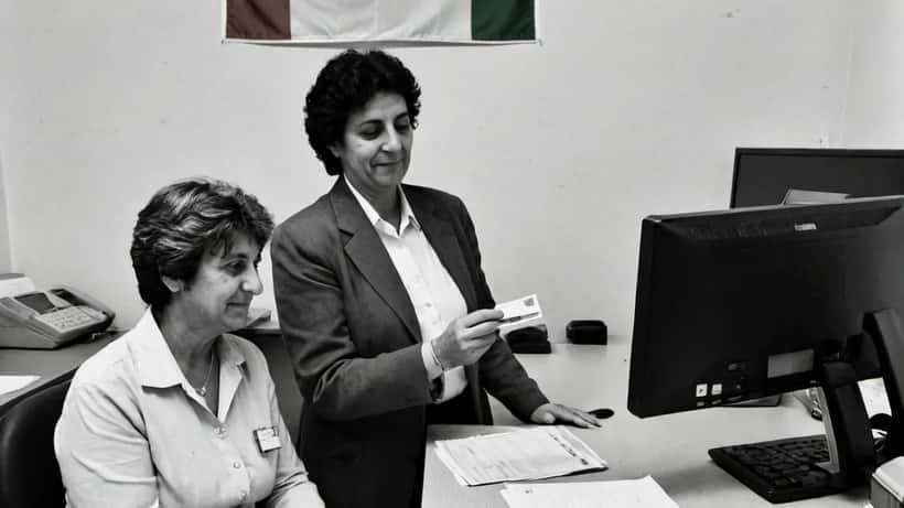 Cittadina italiana allo sportello dell'anagrafe consegna la vecchia carta d'identità cartacea per rinnovarla con la CIE