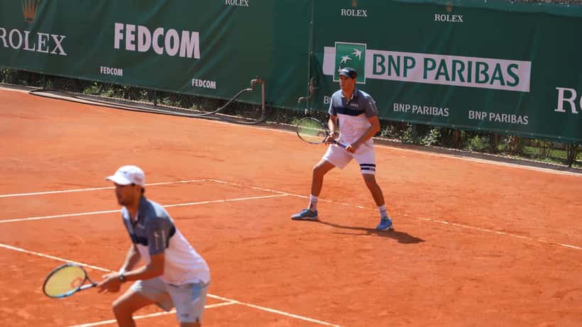 Tenista em quadra de saibro durante o Monte-Carlo Masters, representando os desafios físicos do tênis de alto nível