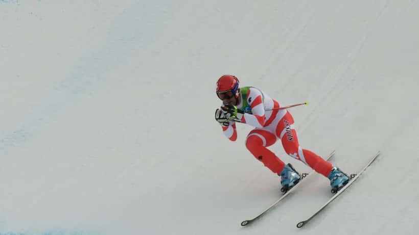 Skieur suisse en descente olympique, représentant l'effort extrême des athlètes de haut niveau