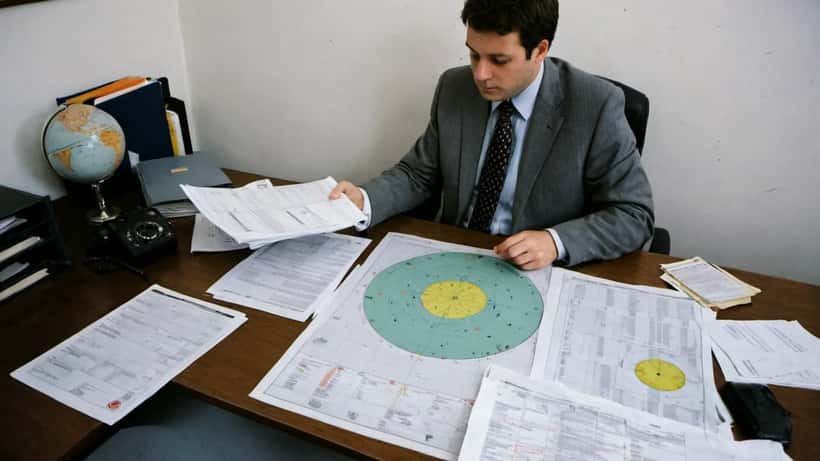 Solicitor reviewing property damage documents and NASA asteroid charts in a London law firm office