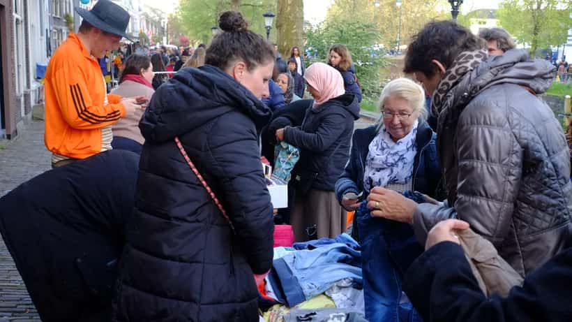 Feestgangers op Koningsnacht in Utrecht, sfeervolle menigte bij nacht
