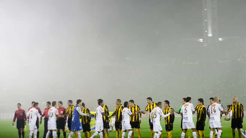 Partida da Copa Libertadores da América com jogadores disputando a bola em campo
