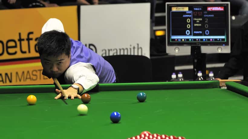 Ding Junhui concentrating at the snooker table during a professional match