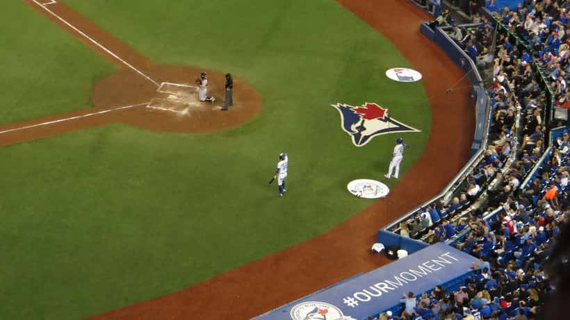 Jugador de béisbol al bate en estadio lleno durante playoffs de la MLB 2026