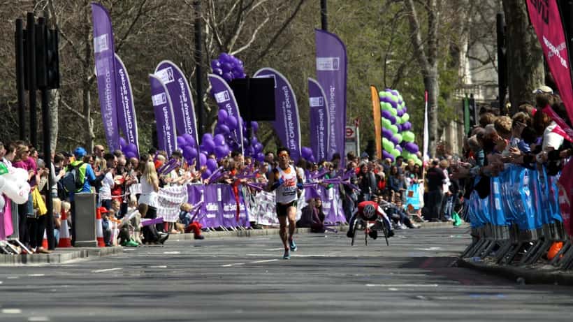Runners taking part in the London Marathon on a crowded city street