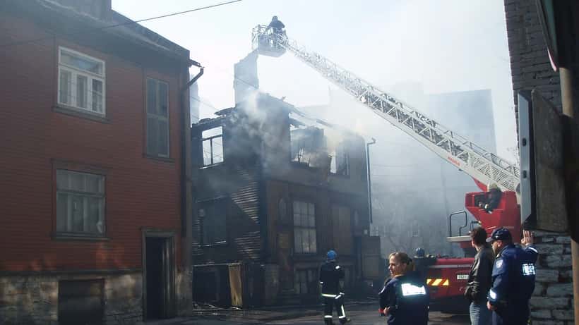 Brandmän bekämpar brand i trähus med vattenslangar