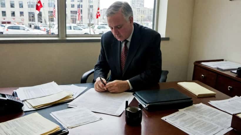 Avocat canadien en droit des affaires révisant un contrat transfrontalier Canada-États-Unis dans un bureau d'Ottawa